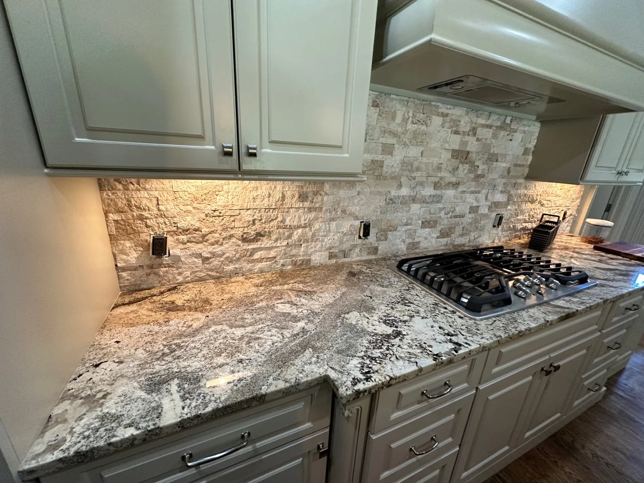Finished kitchen backsplash, countertop, and cooktop detail
