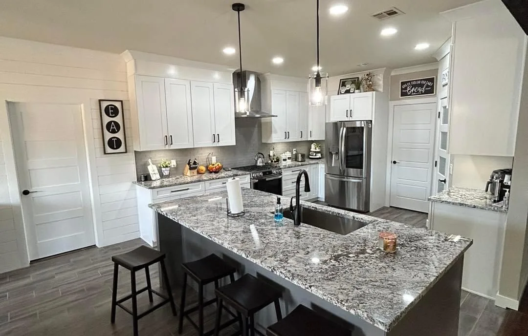 Finished kitchen renovation with granite island and white cabinets
