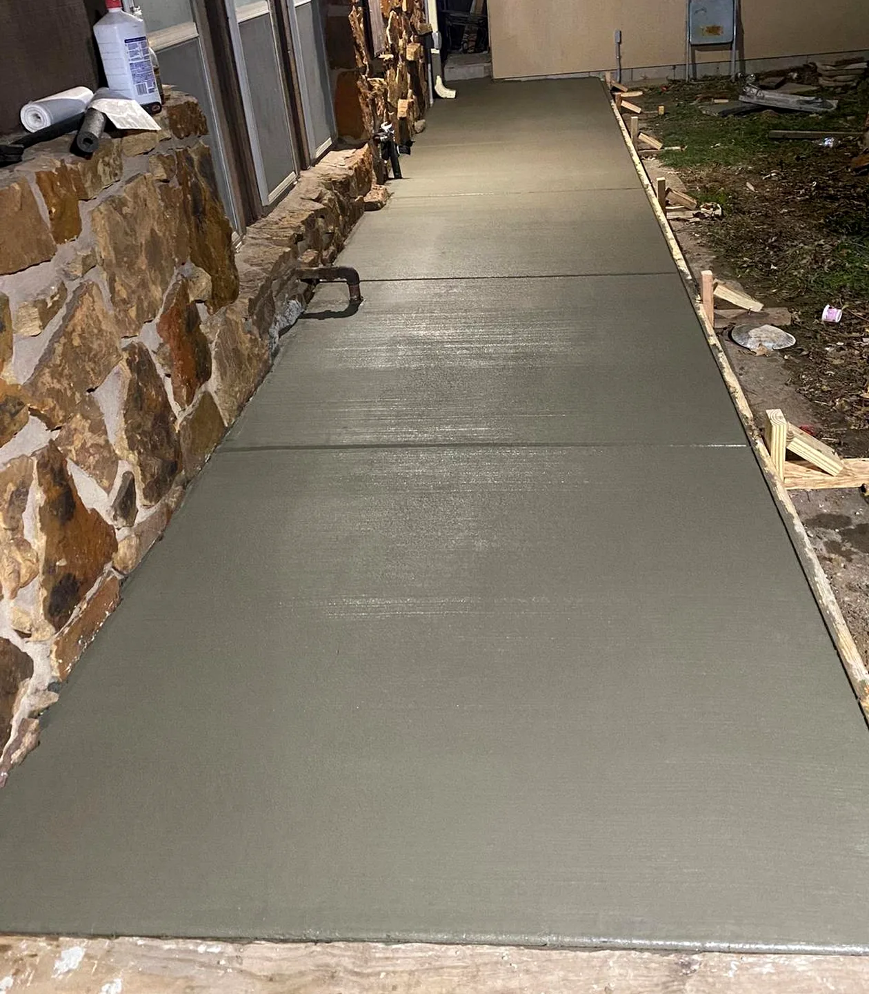 Freshly finished concrete sidewalk beside a home